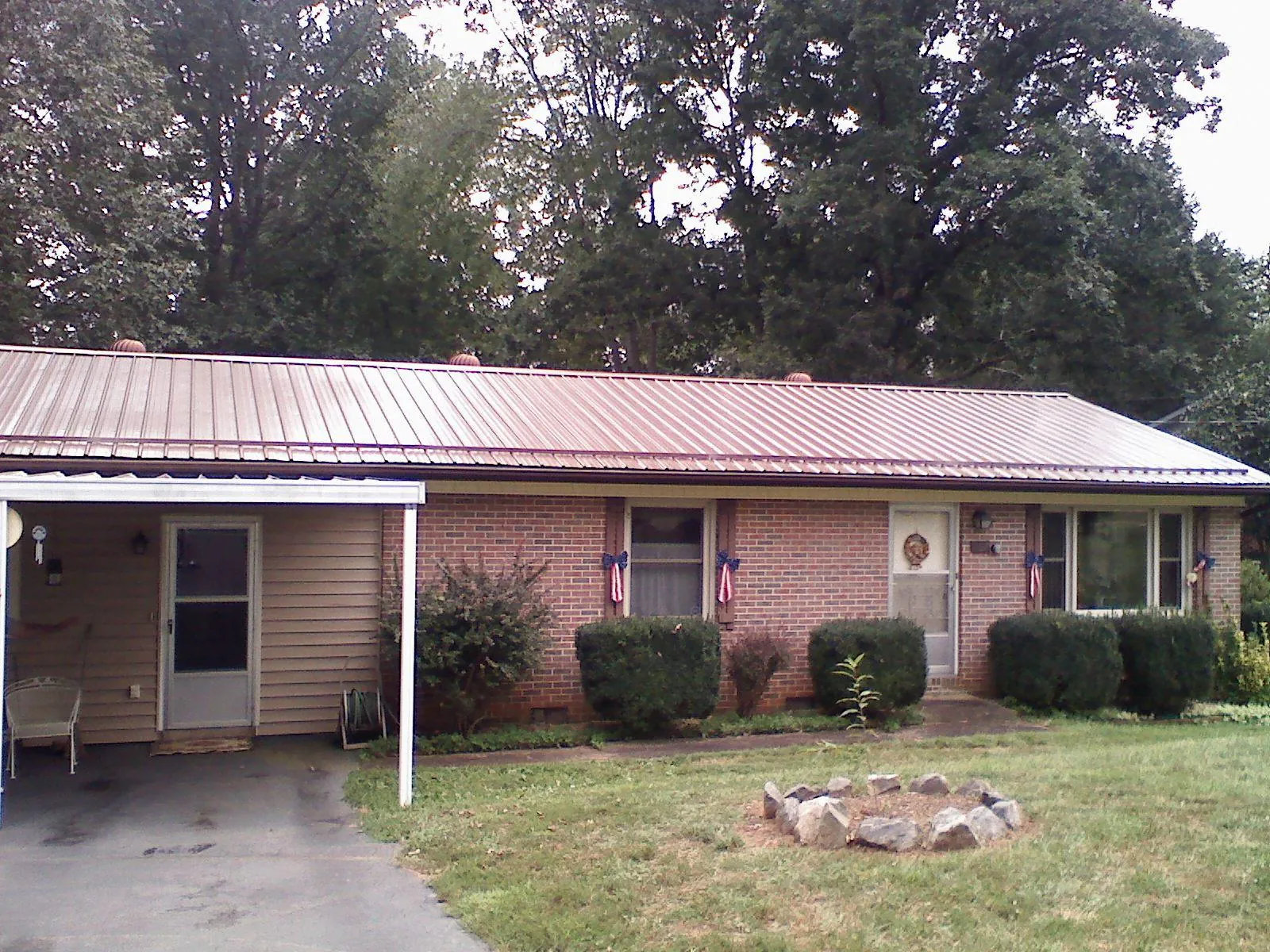 Bronze metal roof and carport on a brick ranch home — Roof Repair work by our crew in Badin