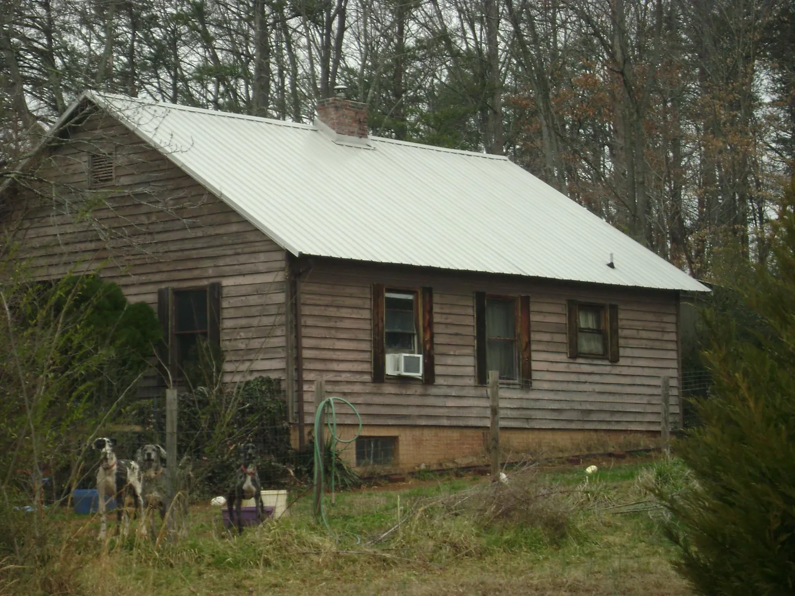 White metal roof on an old wood sided farmhouse, from a Metal Roof Installation job in Badin